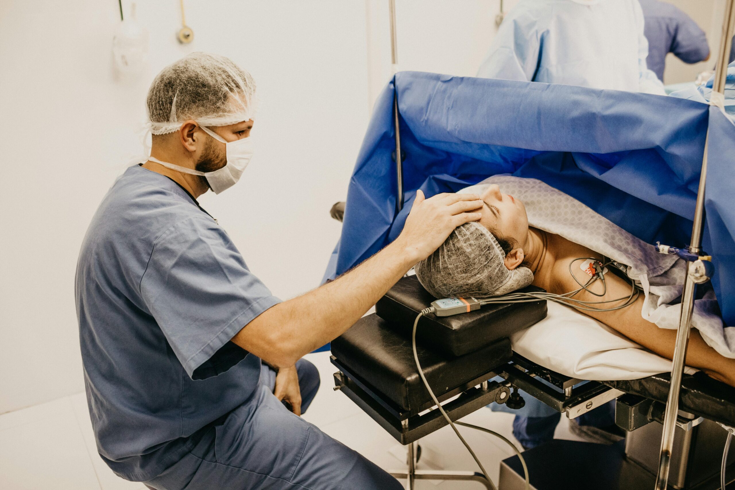 Surgeon offering comfort to a patient about to undergo surgery in a hospital operating room.